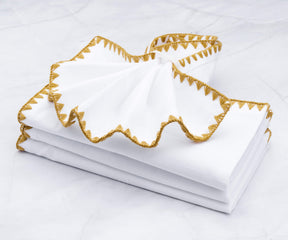 Multiple shell edge wedding napkins with a shimmering gold border