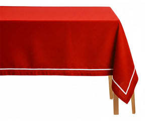 Red rectangular cotton tablecloth with white embroidered design on dining table