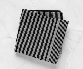 Black and white striped rectangular dish towel displayed on a marble background
