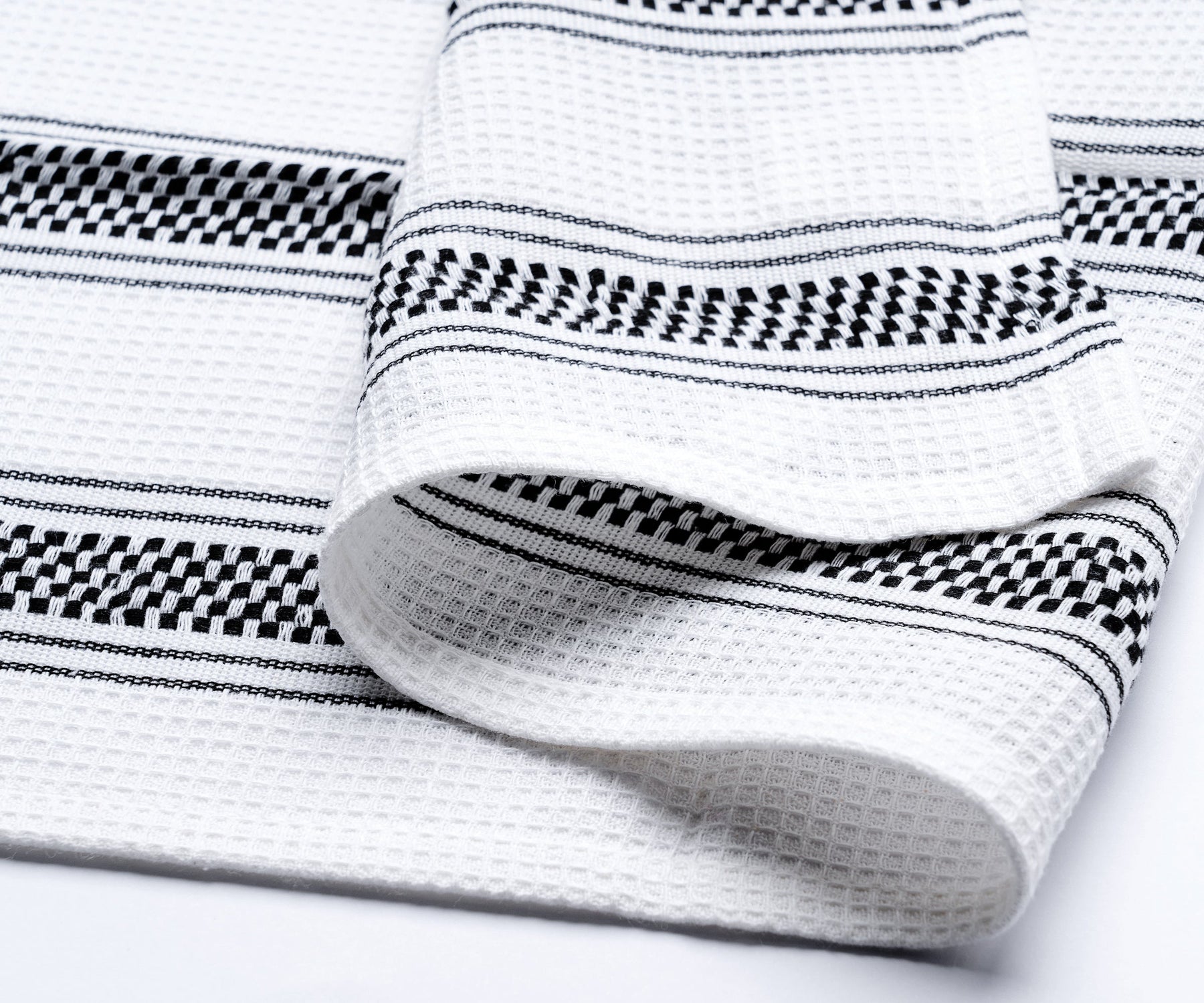 Close-up view of a black kitchen hand towel with white stripes