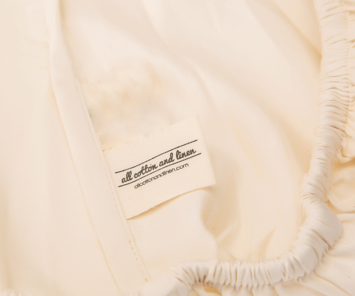 Label detail on the white cotton fitted sheet