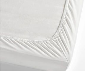 Close-up view of a mattress covered with a cotton fitted sheet