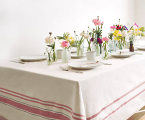 Table decorated with flowers and vases on a French tablecloth