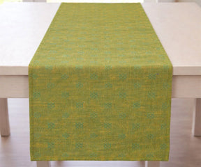 Green and Gold table runner on a wooden table