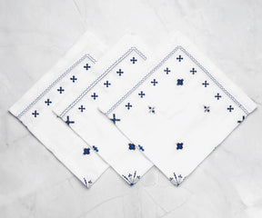White linen napkins Folded napkins showcase intricate designs for added elegance.