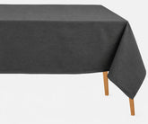 Dark grey rectangular tablecloth draped over a dining table with visible wooden legs