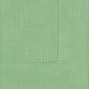 Set of sage green cloth napkins in various sizes, styled with matching green table linen and neutral dinnerware.

