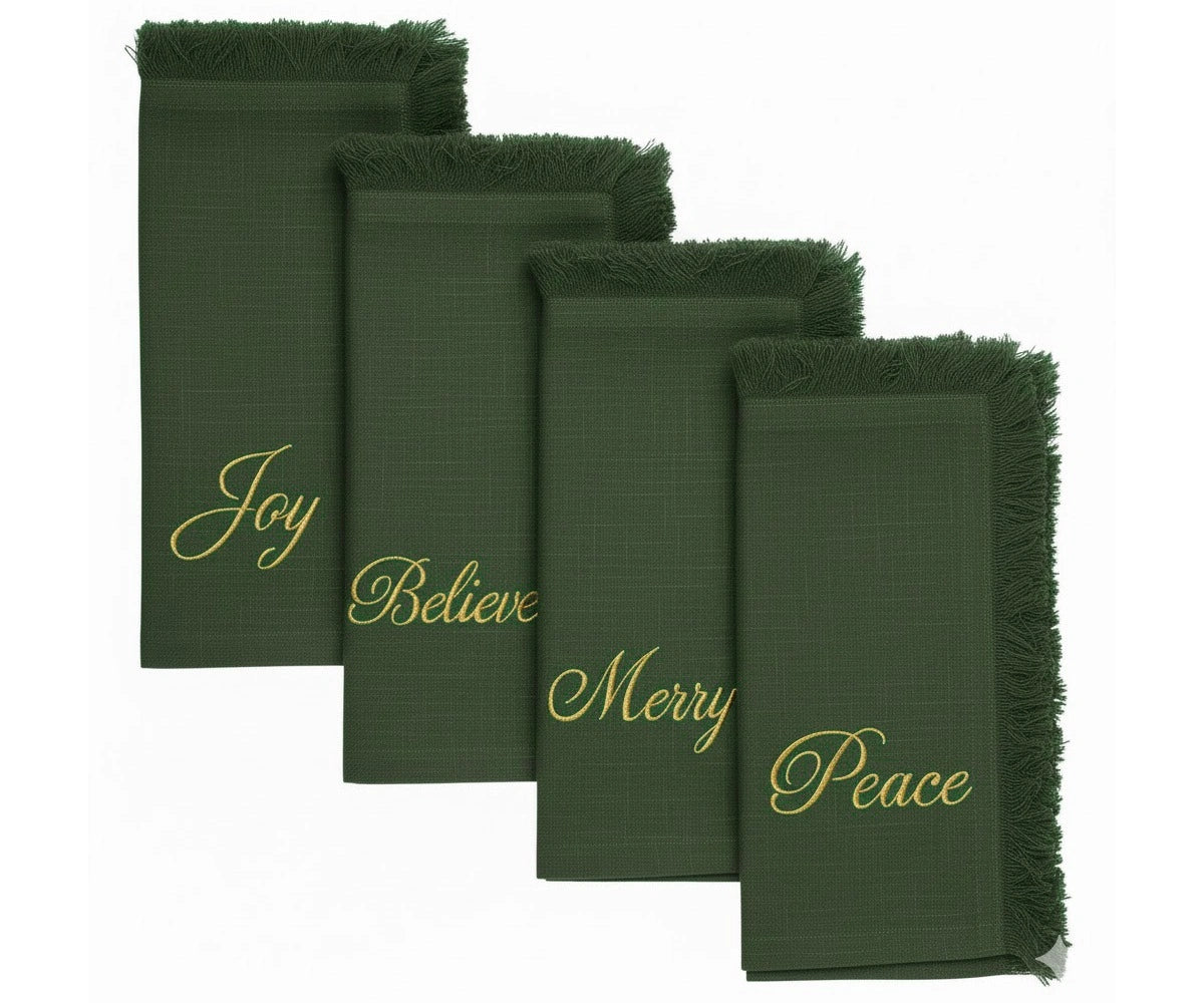 Festive green embroidered napkins with gold lettering and fringed edges for Christmas dining