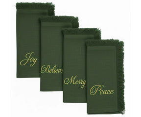 Festive green embroidered napkins with gold lettering and fringed edges for Christmas dining
