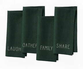 Green embroidered cotton dinner napkin with white stitched “Laugh, Family, Share, Gather” text — farmhouse table decor.