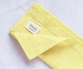 Elegant yellow fabric napkins paired with round cotton tablecloth