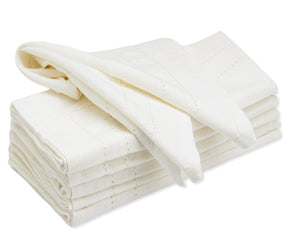 Pile of white cloth dinner napkins against a white backdrop
