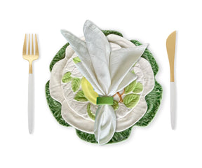 Ivory napkins arranged in a sophisticated fold on a rustic wooden table, enhancing the charm of the dining setup.