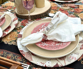 Dining table arrangement featuring pink and white plates with coordinating napkins