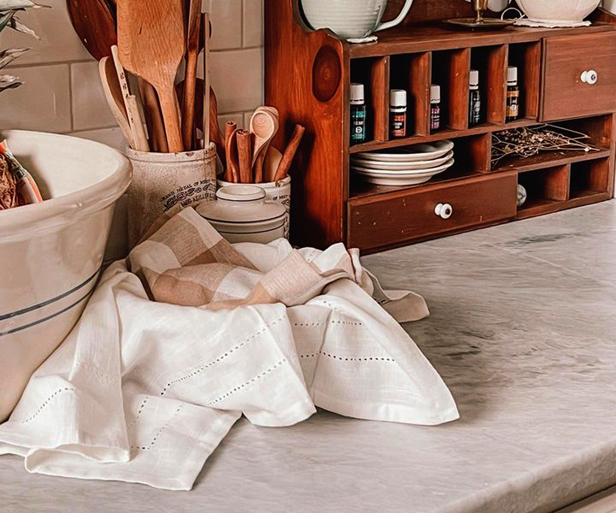 Kitchen scene with a white cloth napkin by the sink on a wooden counter