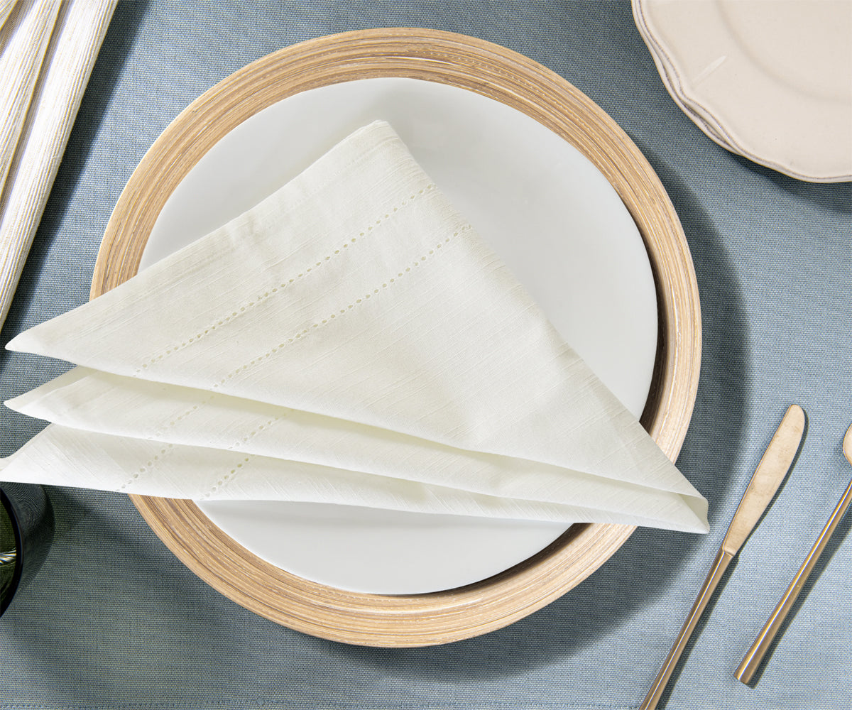 Elegant white dinner napkin presented on a plate with cutlery