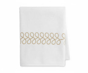 High-quality beige and white bath towels showing embroidered pattern and plush texture