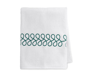 Embroidered white and green bath towels neatly folded, showcasing luxury cotton texture