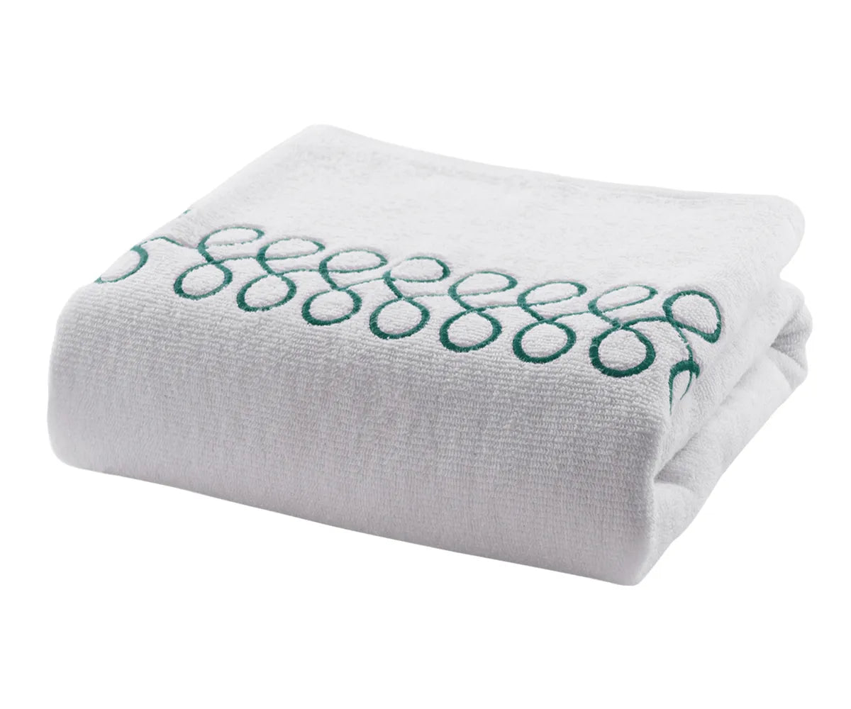 Plush cotton bath towels in white with green embroidery offering high absorbency