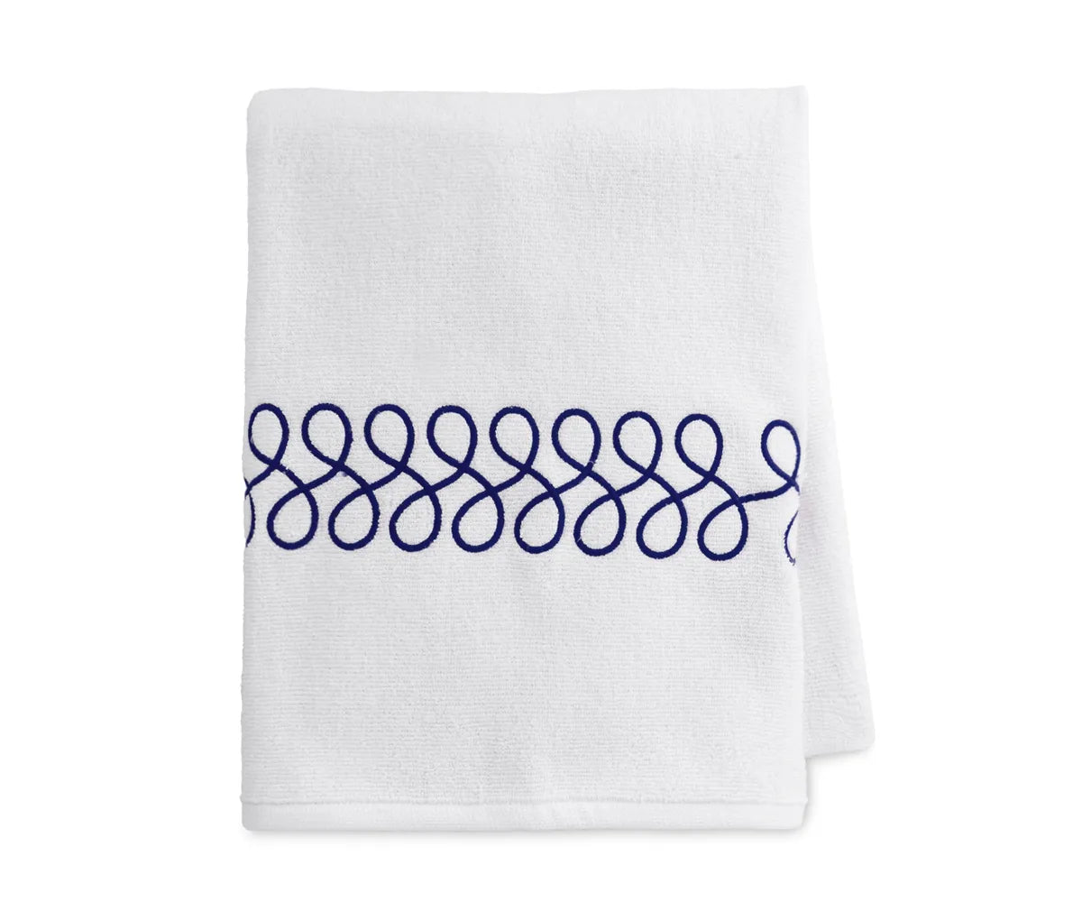 Embroidered navy and white bath towels neatly folded showcasing luxury cotton texture