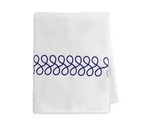 Embroidered navy and white bath towels neatly folded showcasing luxury cotton texture
