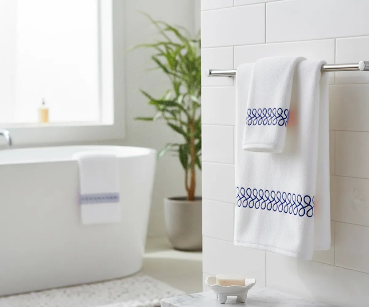 Soft white bath towel with navy embroidered border for stylish bathroom décor