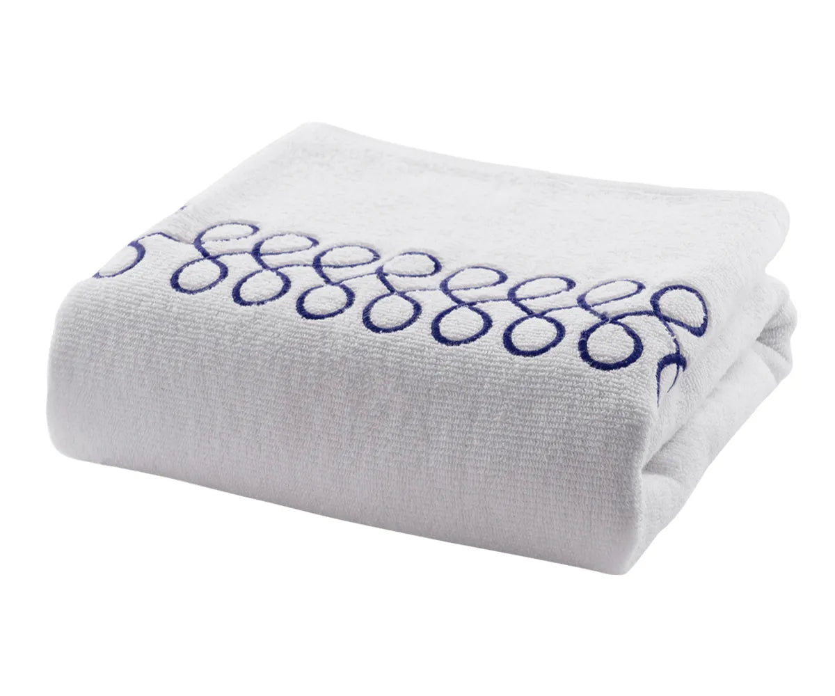 Plush cotton bath towels in white with navy embroidery offering high absorbency