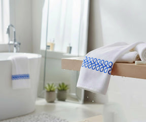 White cotton embroidered bath towel with blue trim, soft absorbent luxury bath towel, elegant bathroom towel for everyday use