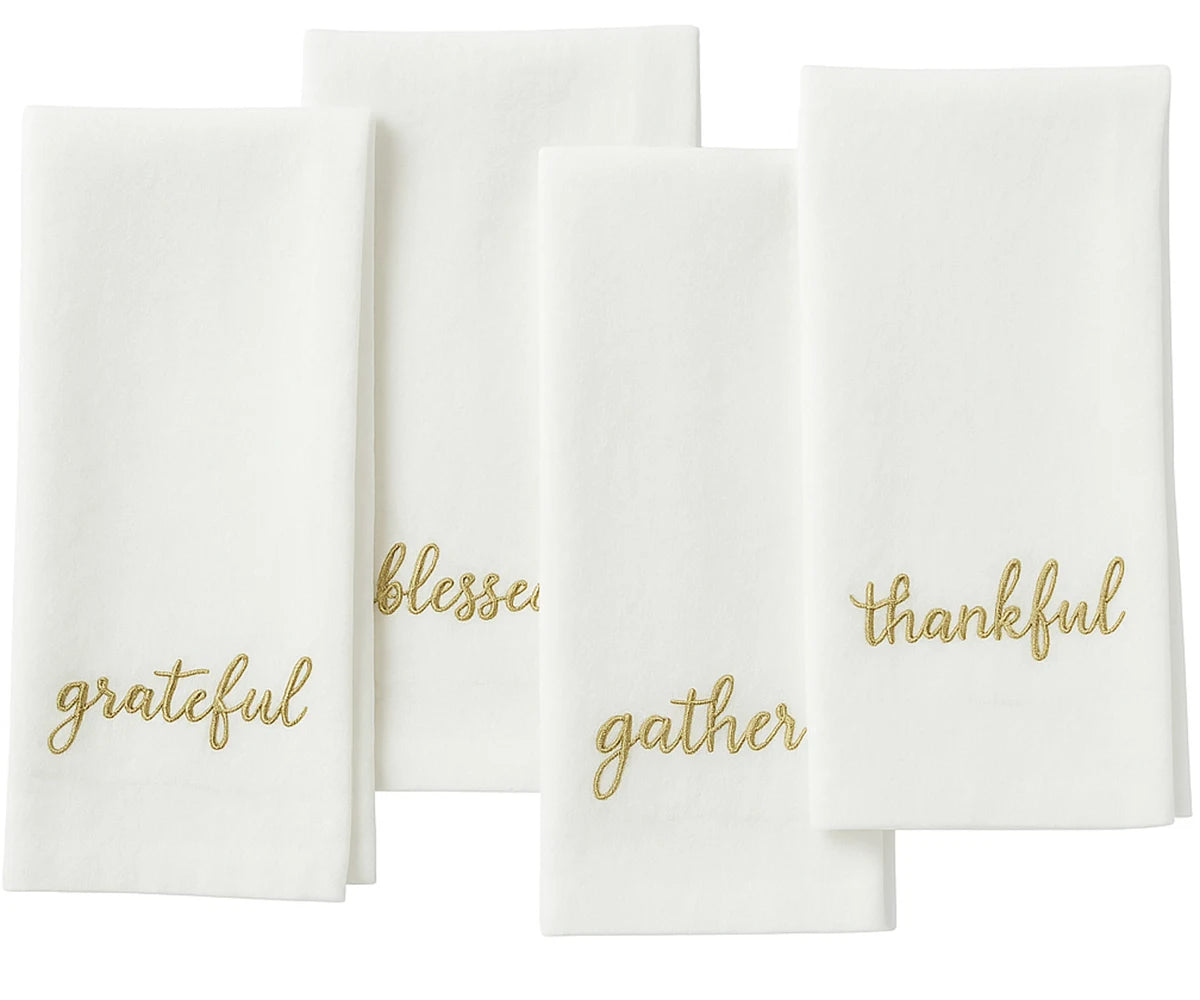 Ivory sentiment embroidered napkin in gold stitching for elegant Christmas table décor.