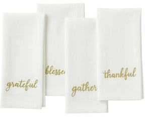 Ivory sentiment embroidered napkin in gold stitching for elegant Christmas table décor.