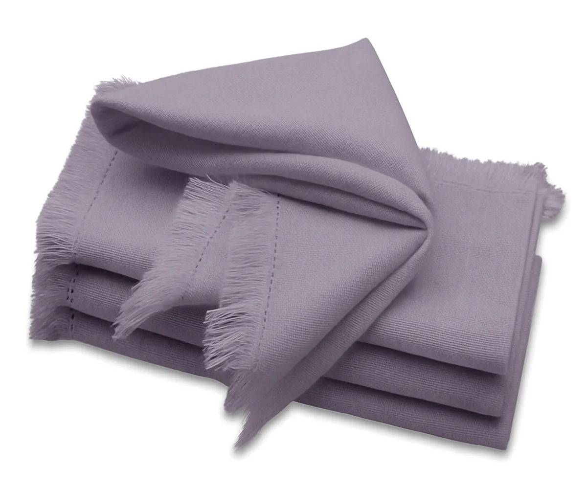 Lavender cotton fringe cloth napkins folded on a dining table – reusable eco-friendly wedding napkins