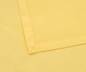Reusable lemon yellow cloth napkins styled with a neutral table runner.