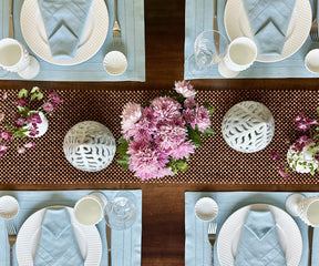 Elevate your dining table with green fabric placemats, providing charm and protection, creating a stylish and enjoyable mealtime expe