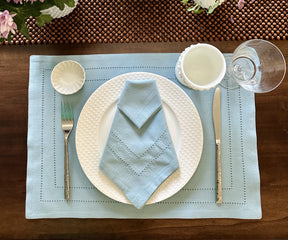 Blue hemstitched napkins with decorative stitching along the edges.