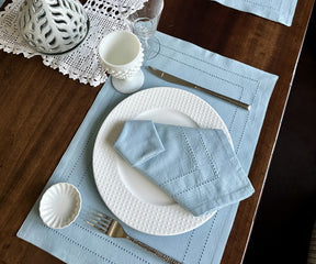 Elegant dinner table setup featuring Cloth Dinner Napkins with blue placemat and pristine white plate