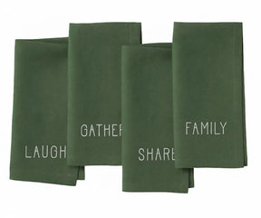 Light green cotton napkin with delicate white embroidery reading “Laugh, Family, Share, Gather” — soft farmhouse style.