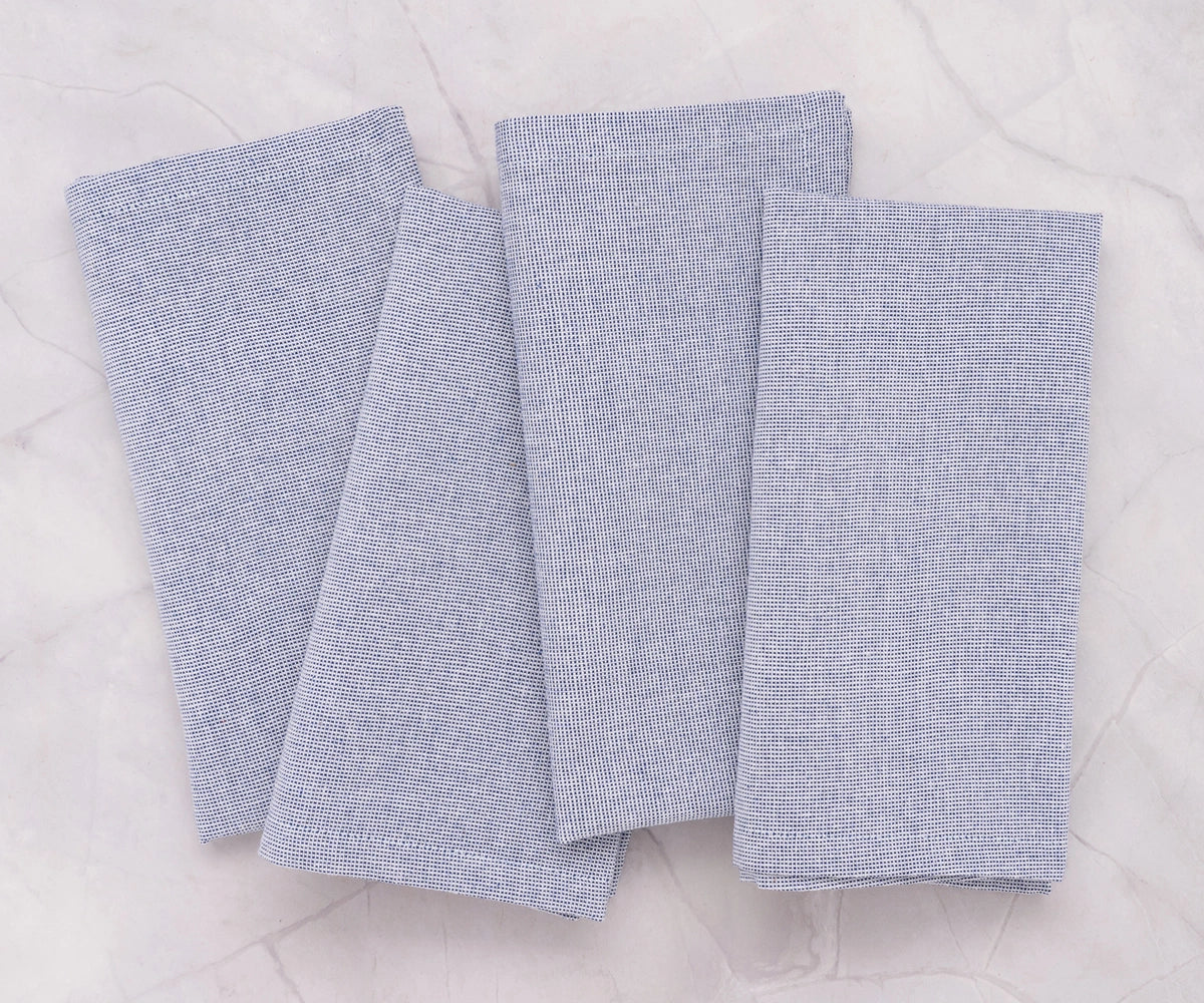 Set of light blue cloth napkins arranged elegantly for a casual dinner setting.