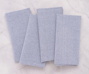 Set of light blue cloth napkins arranged elegantly for a casual dinner setting.