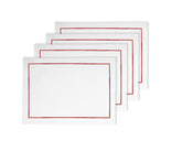 A set of four rectangular magenta fabric placemats with a red border, neatly stacked on top of each other.