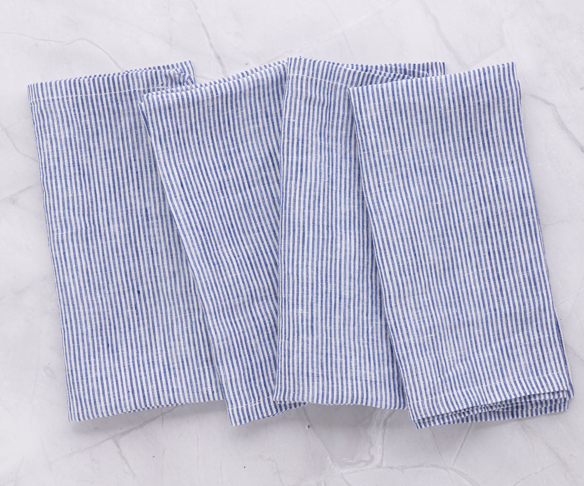 A group of four linen napkins with blue and white stripes