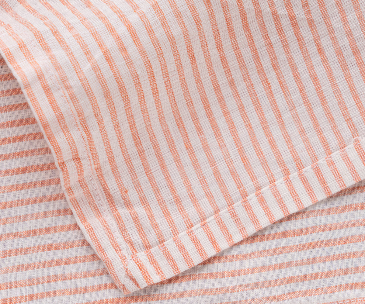 A neatly folded pink and white striped linen napkin on a clean surface