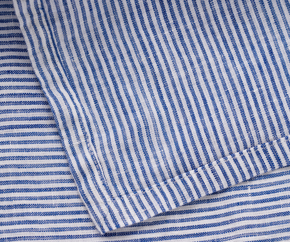 A detailed view of a blue and white striped linen napkin's texture
