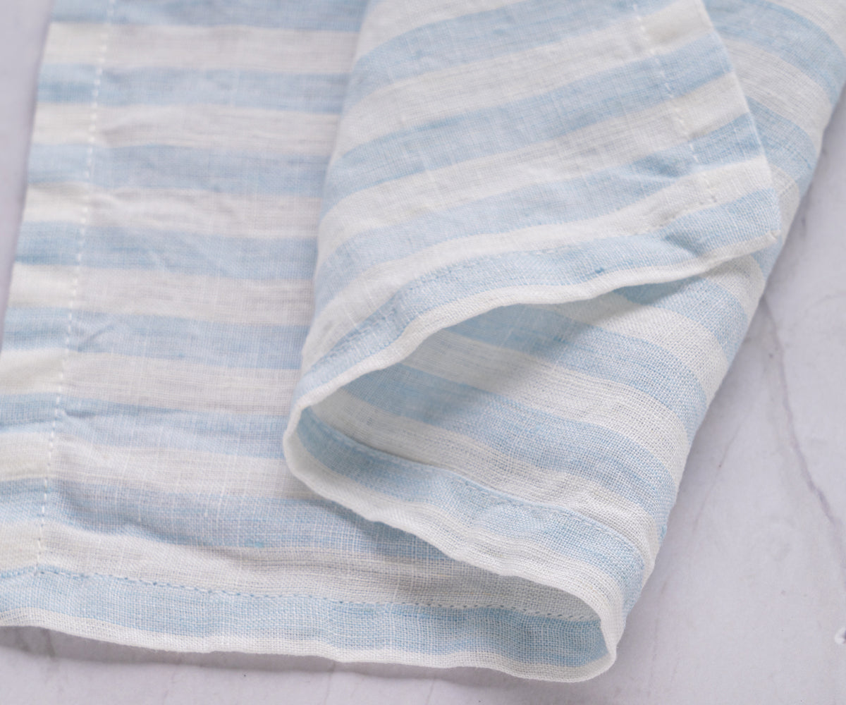 A blue and white striped linen napkin on a white background