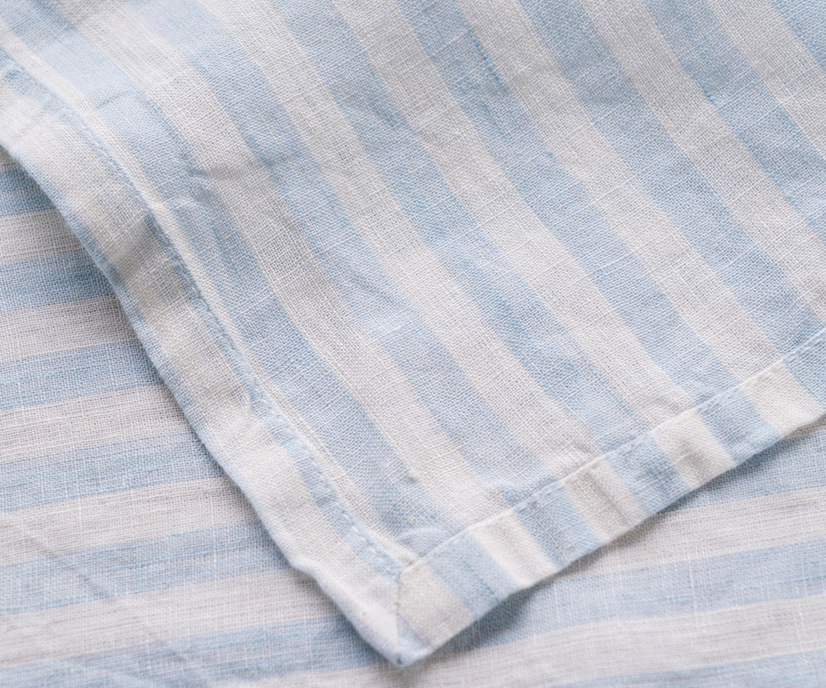 A close-up view of a blue and white striped linen napkin