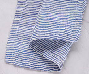 An individual blue and white striped linen napkin laid flat