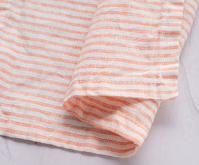 A close-up shot of the fabric pattern on a pink and white striped linen napkin