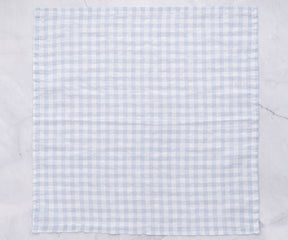 Single blue and white gingham linen napkin on a flat surface