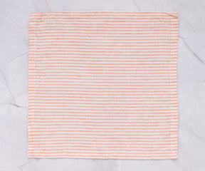 A single striped linen napkin resting on a marble background