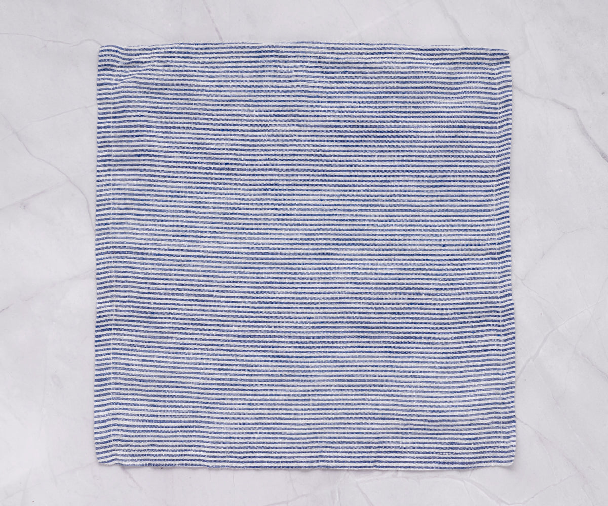 A blue linen napkin positioned on a marble tabletop