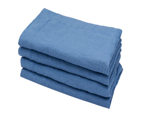 Detail shot of a stack of blue linen napkins, highlighting the fabric's texture and the precise folding of each piece.